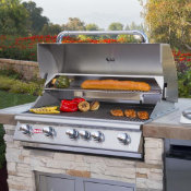 outdoor grill in an outdoor kitchen island with food grilling